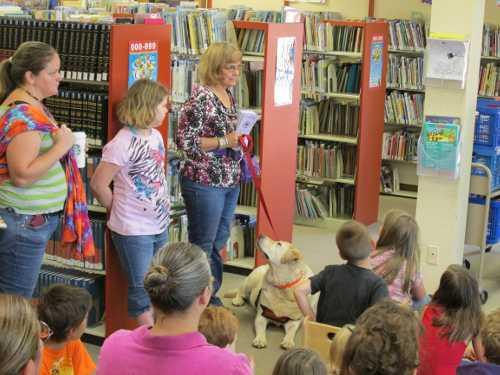 OurKnee, the only canine member of the Friends of the Lake County Library, and his human friend Leanne Harvey attended the summer reading program awards party at Lakeport Library in Lakeport, Calif., to encourage people to join the Friends of the Library. Courtesy photo. summer2013readinganddog