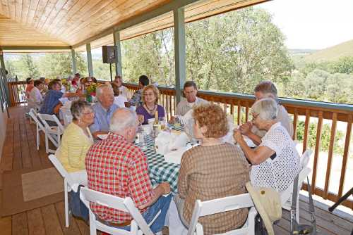 Enjoying lunch on the porch of the Ely Stage Stop during the inaugural “Picnic on the Porch” on Saturday, June 22, 2013, in Kelseyville, Calif. Photo by Greg Blinn. 062213elypicnictable
